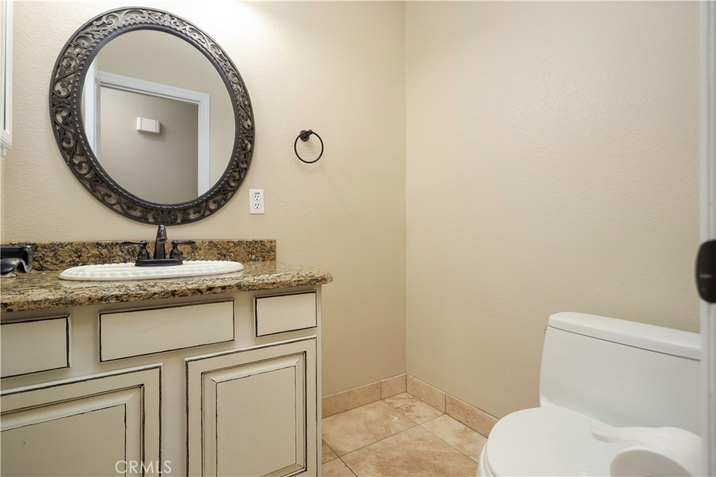 42561 25th Street West Lancaster, CA 93536 - Photo 28 of 41 a bathroom with a granite countertop toilet sink and mirror