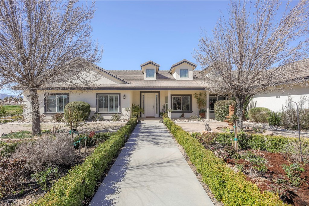 42561 25th Street West Lancaster, CA 93536 - Photo 3 of 41 a front view of a house with a garden and plants