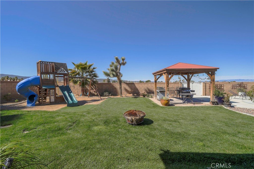 42561 25th Street West Lancaster, CA 93536 - Photo 36 of 41 a view of a backyard with table and chairs under an umbrella
