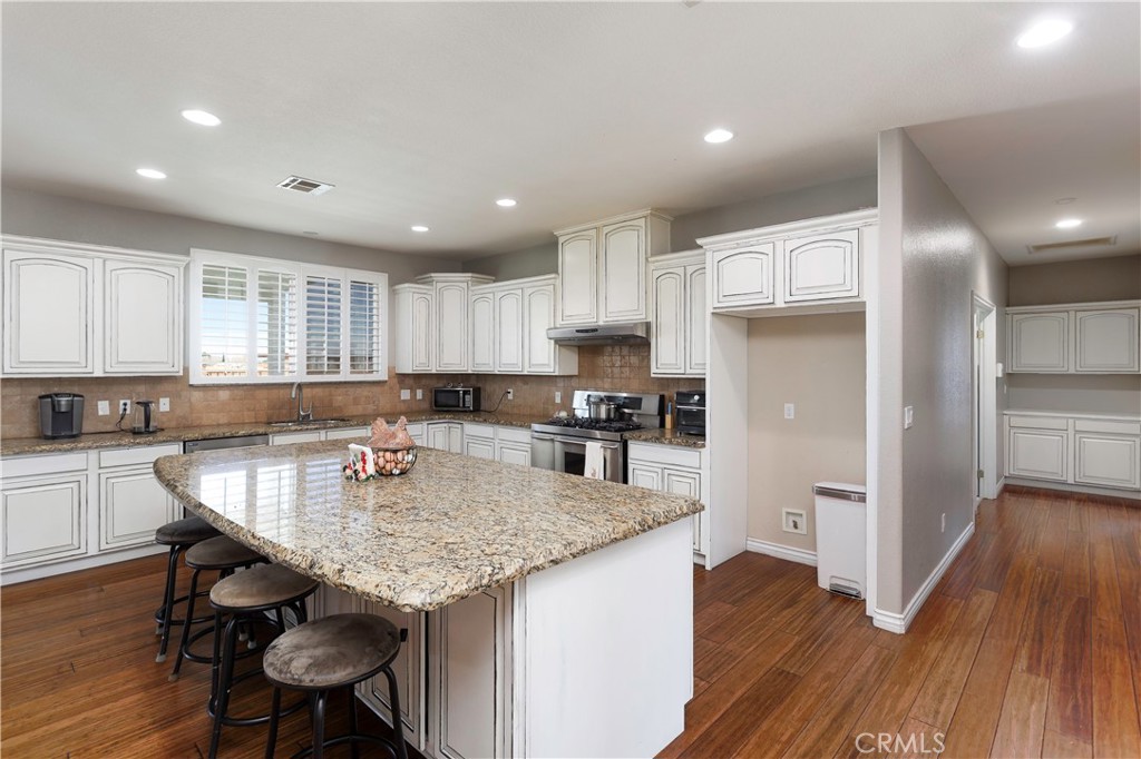 42561 25th Street West Lancaster, CA 93536 - Photo 8 of 41 a kitchen with granite countertop kitchen island wooden floors and center island
