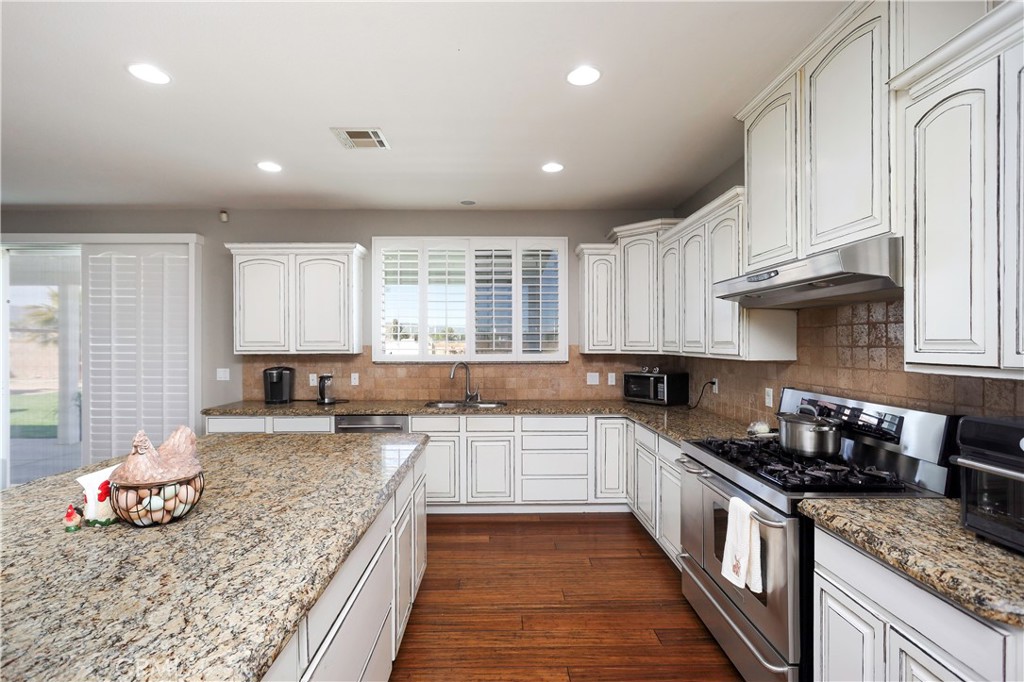 42561 25th Street West Lancaster, CA 93536 - Photo 9 of 41 a kitchen with granite countertop a sink stove and cabinets