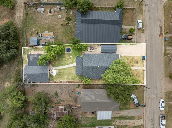 aerial view of a house with a yard and a large tree