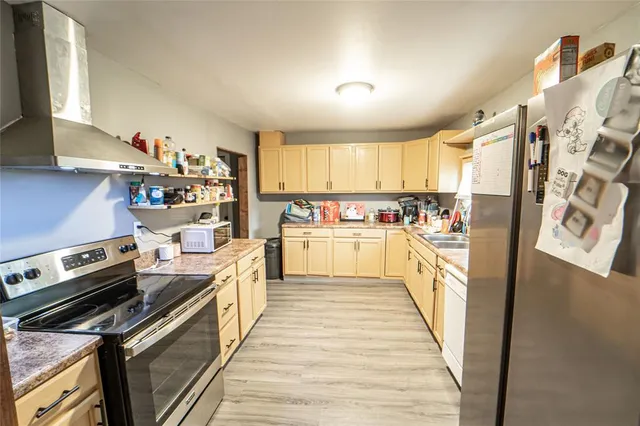 a kitchen with stainless steel appliances a stove a sink and white cabinets