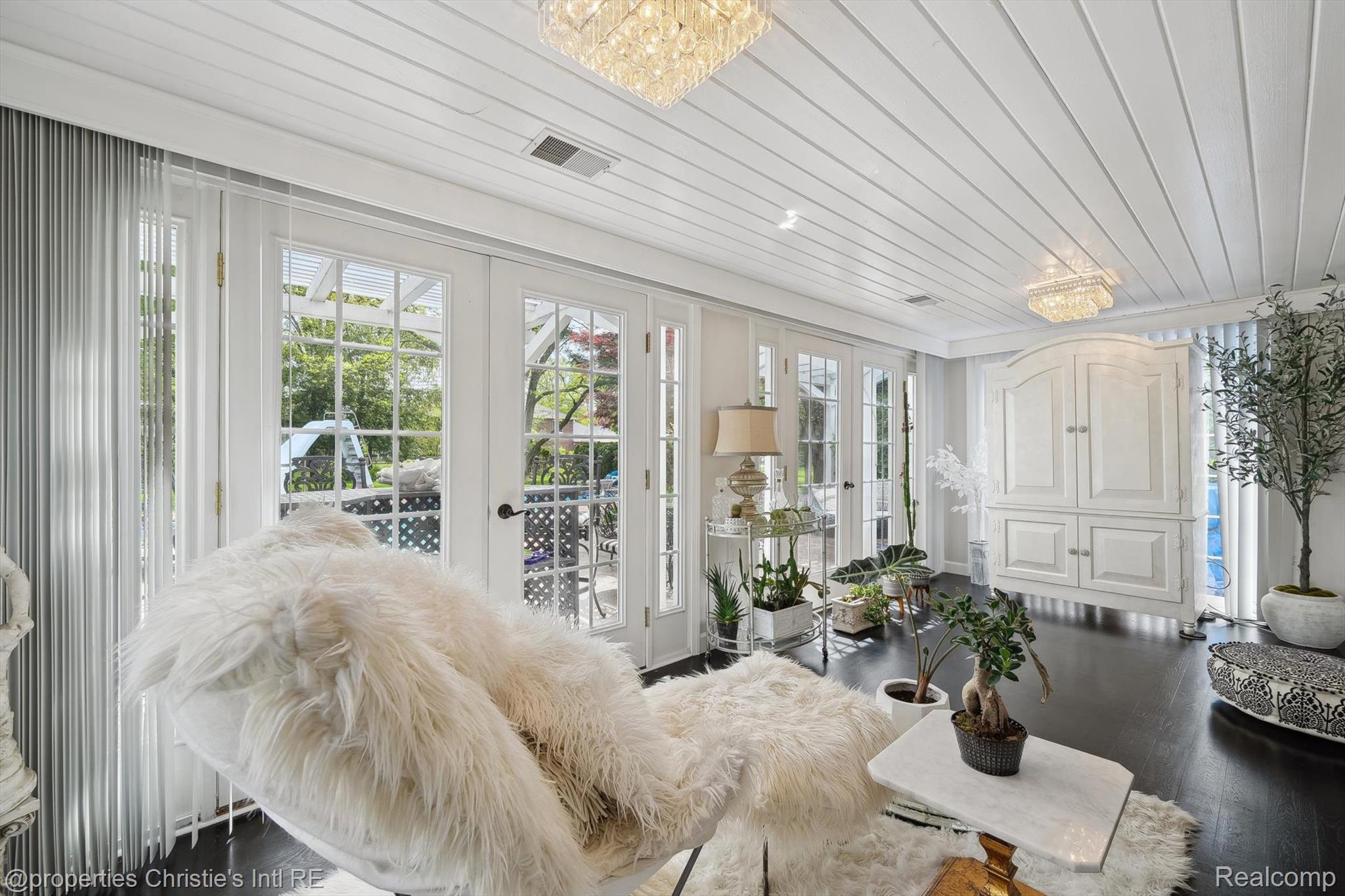 511 South Gulley Road Dearborn, MI 48124 - Photo 27 of 43 White paneled ceiling with dual crystal chandeliers, dark wood-finish flooring, multiple French patio doors, and a built-in white storage cabinet