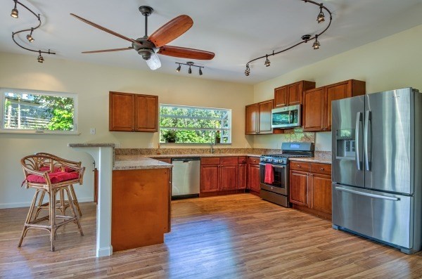 4386 Upa Road, Unit 2 Koloa, HI 96756 - Photo 3 of 25 a kitchen with stainless steel appliances granite countertop a refrigerator a stove top oven a sink dishwasher and wooden floor