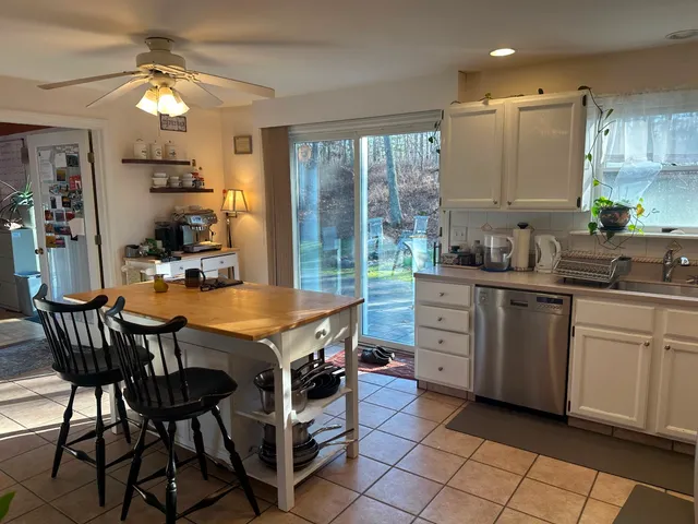a kitchen with a table chairs sink and cabinets