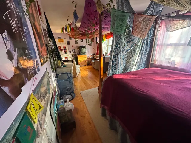 a bed sitting in a bedroom next to a window