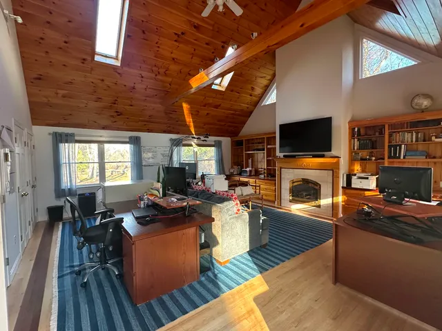 a living room with fireplace furniture flat screen tv and wooden floor