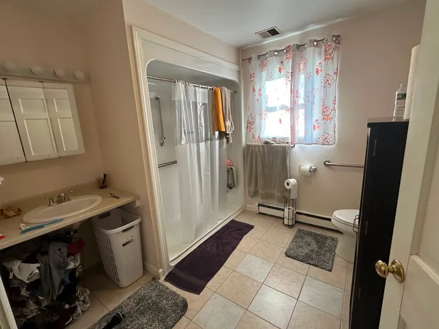 a living room with furniture a flat screen tv and kitchen view
