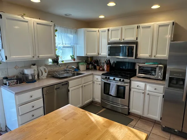 a kitchen with stainless steel appliances granite countertop a stove a sink and a refrigerator