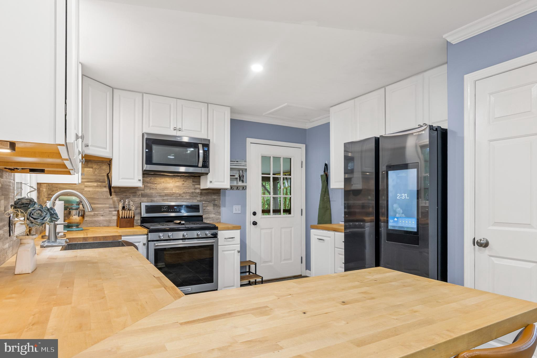 1425 Jacks Shop Road Rochelle, VA 22738 - Photo 15 of 56 a kitchen with granite countertop a refrigerator and a stove top oven