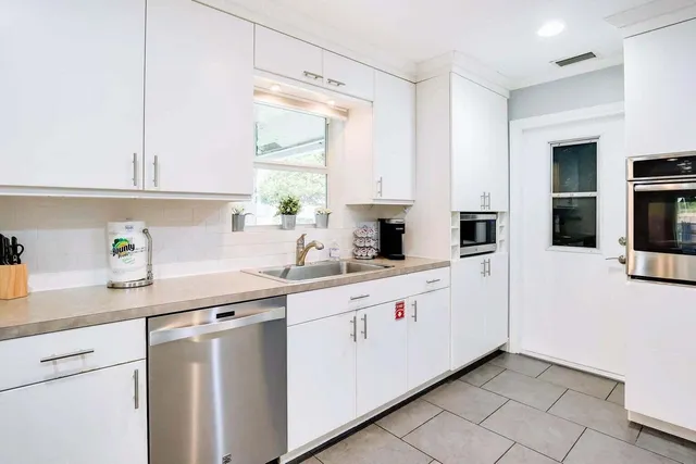 a kitchen with white cabinets and white appliances