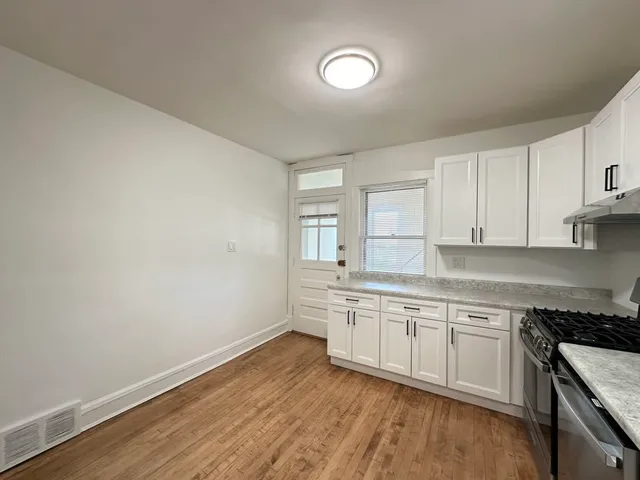 a kitchen with granite countertop white cabinets and white appliances