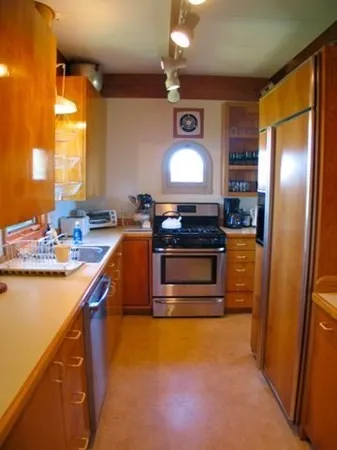 a kitchen with stainless steel appliances granite countertop a stove a sink and a refrigerator