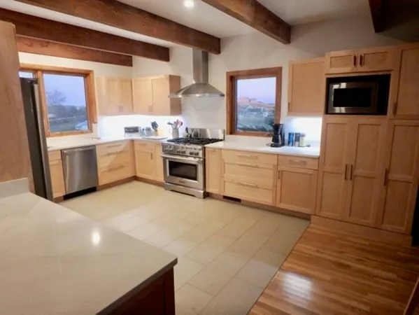 a large kitchen with a stove a sink and a microwave