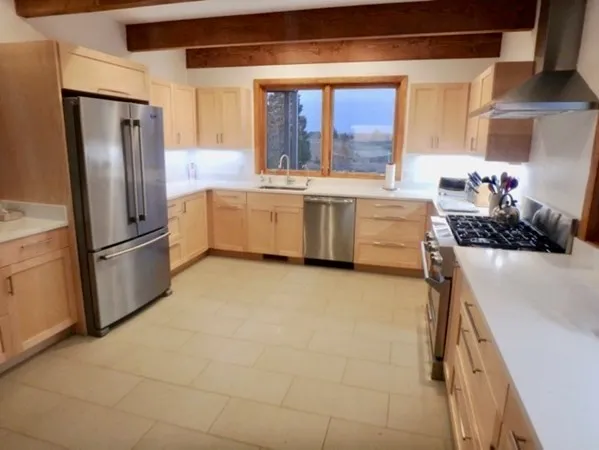 a kitchen with stainless steel appliances a refrigerator sink and cabinets
