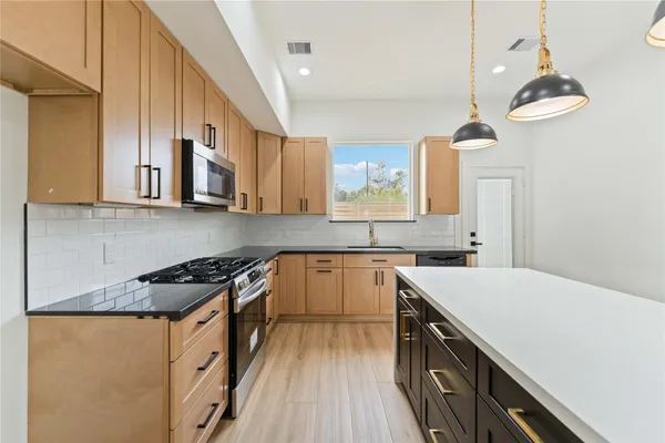 a kitchen with stainless steel appliances a sink stove and cabinets