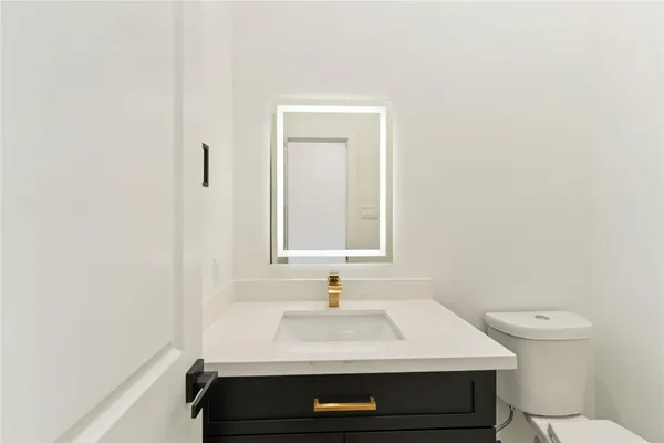a bathroom with a sink toilet and mirror