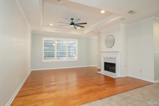 a view of an empty room with a fireplace and a fan