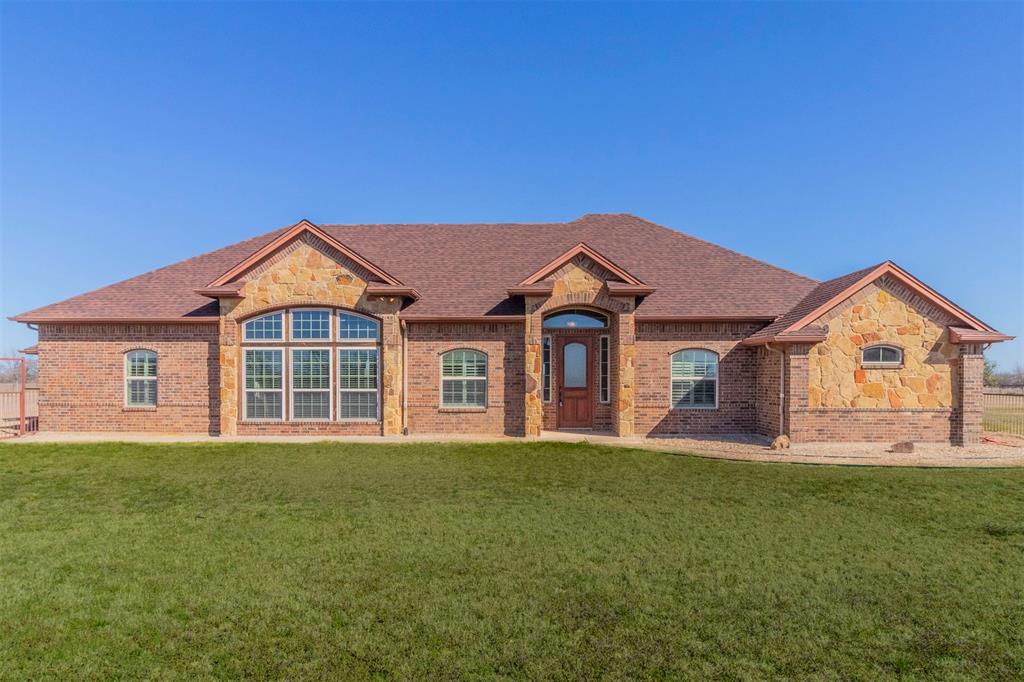 View of front of house with brick siding, stone siding, a shingled roof, and a front lawn