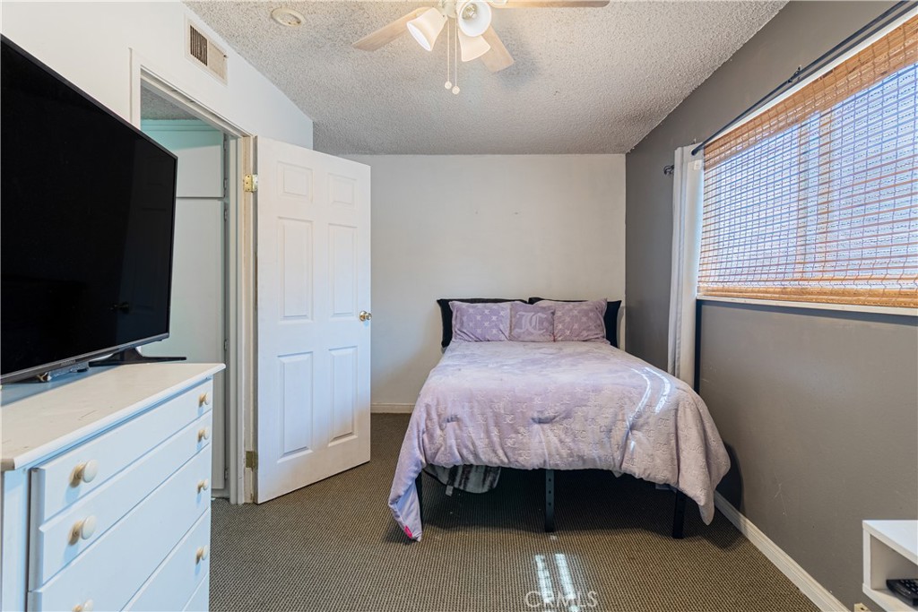 10654 White Oak Drive Riverside, CA 92505 - Photo 16 of 29 a bedroom with a bed and a flat tv screen on dresser