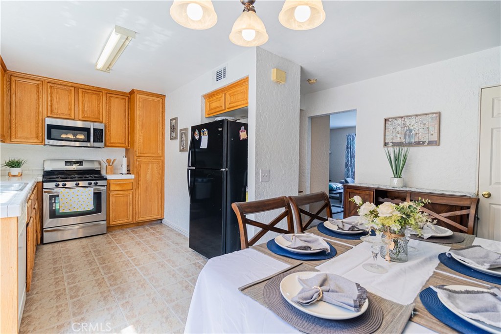 10654 White Oak Drive Riverside, CA 92505 - Photo 8 of 29 a kitchen with stainless steel appliances kitchen island granite countertop a table and chairs in it