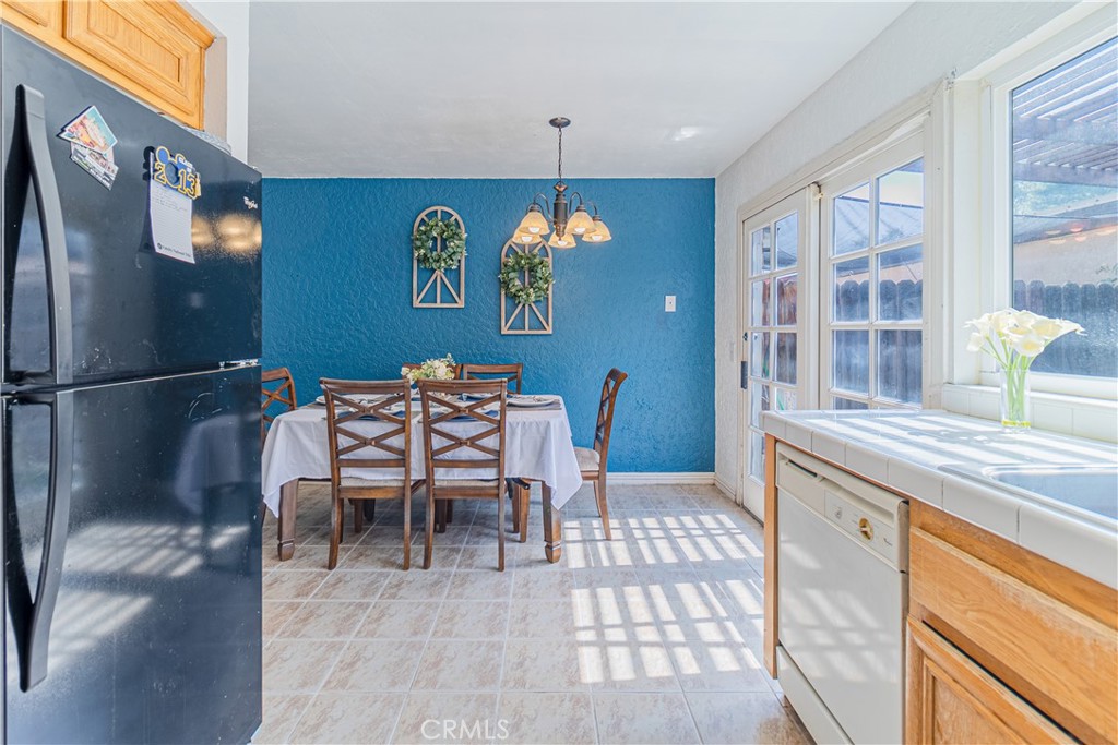 10654 White Oak Drive Riverside, CA 92505 - Photo 9 of 29 a kitchen with stainless steel appliances granite countertop a stove a refrigerator a dining table and chairs with wooden floor