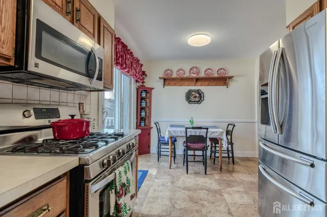 a kitchen with a refrigerator and a dining table