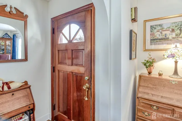 a room with painting on the wall and a potted plant
