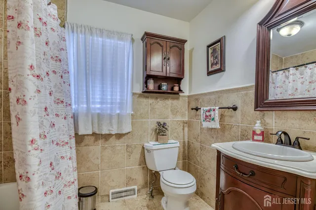 a bathroom with a granite countertop toilet sink and mirror