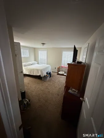 a bed sitting in a bedroom next to a window