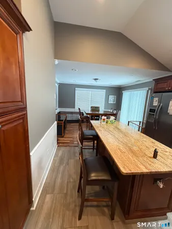 a dining hall with stainless steel appliances kitchen island a stove a refrigerator with a dining table and chairs next to a window