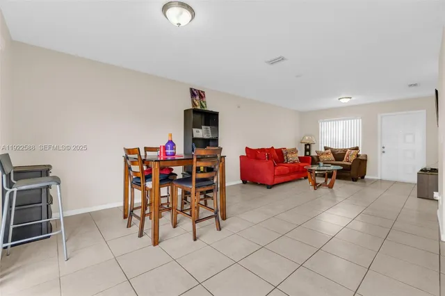 a living room with furniture and a dining table