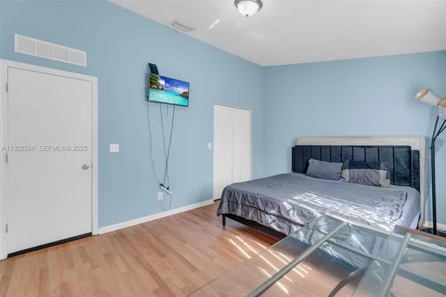 a bedroom with a bed and a painting on the wall