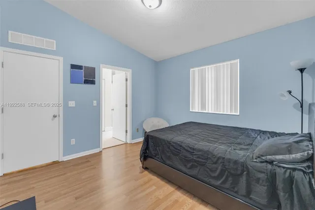 a bedroom with a bed and wooden floor