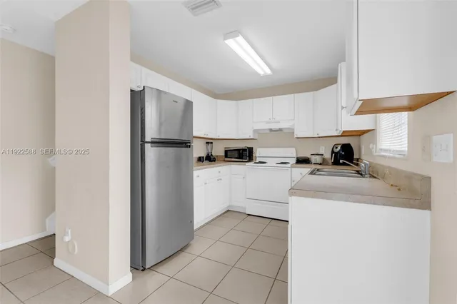a kitchen with a refrigerator sink and cabinets