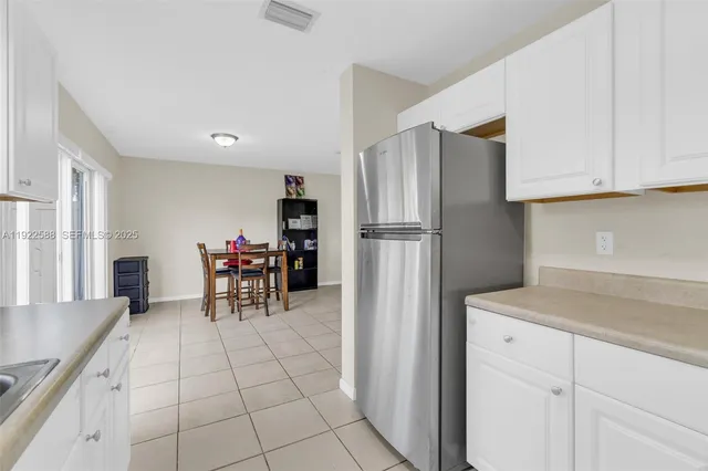 a kitchen with a refrigerator a table and chairs
