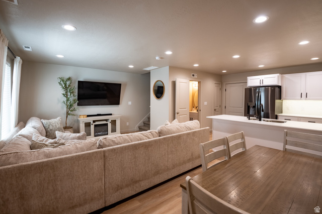 1787 North 1280 East Payson, UT 84651 - Photo 4 of 22 Open-concept living space featuring wood-finish flooring, recessed lighting, and a white entertainment console with an electric fireplace