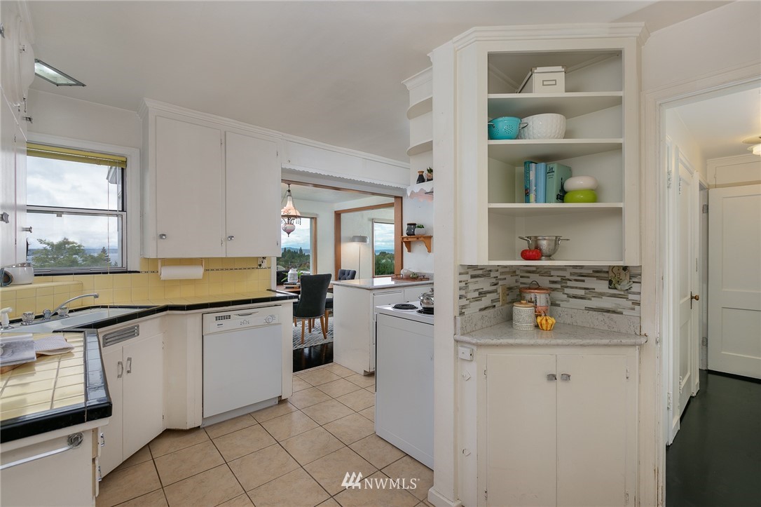 6712 42nd Avenue Southwest Seattle, WA 98136 - Photo 11 of 19 a kitchen with white cabinets and appliances