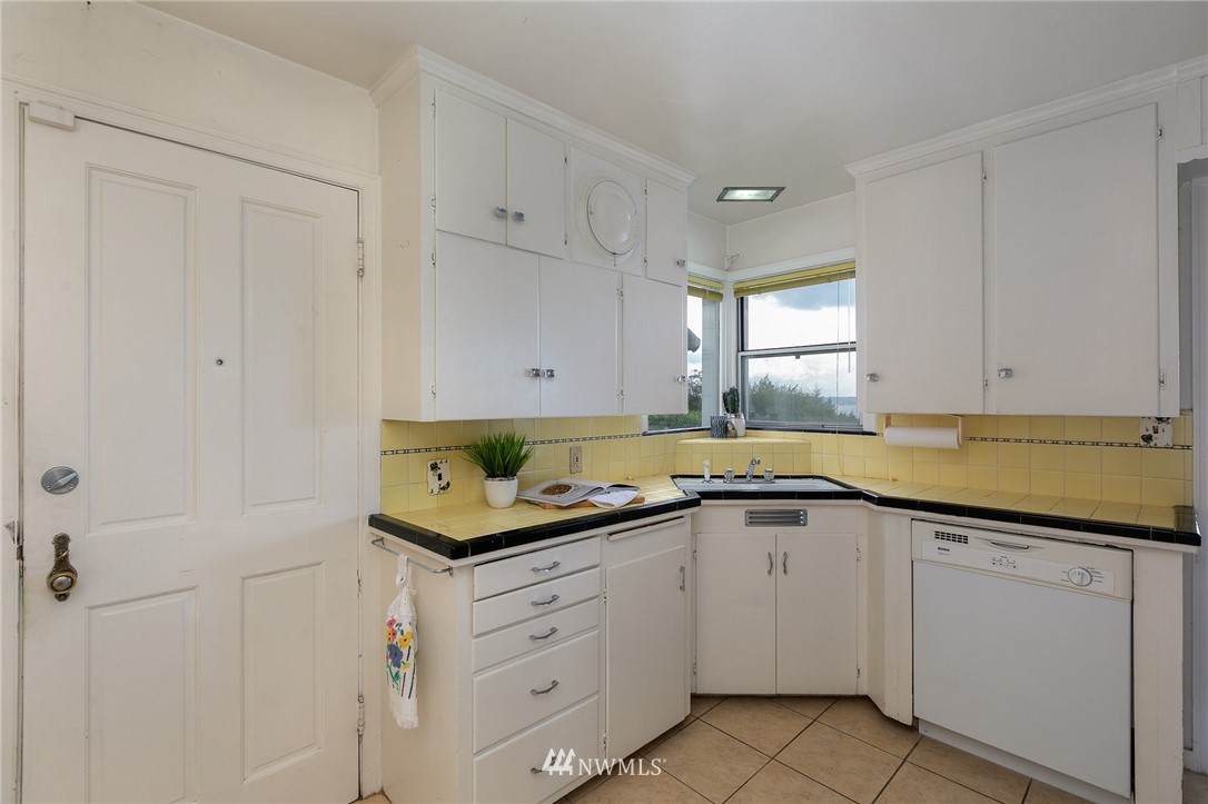 6712 42nd Avenue Southwest Seattle, WA 98136 - Photo 12 of 19 a kitchen with white cabinets appliances and a sink