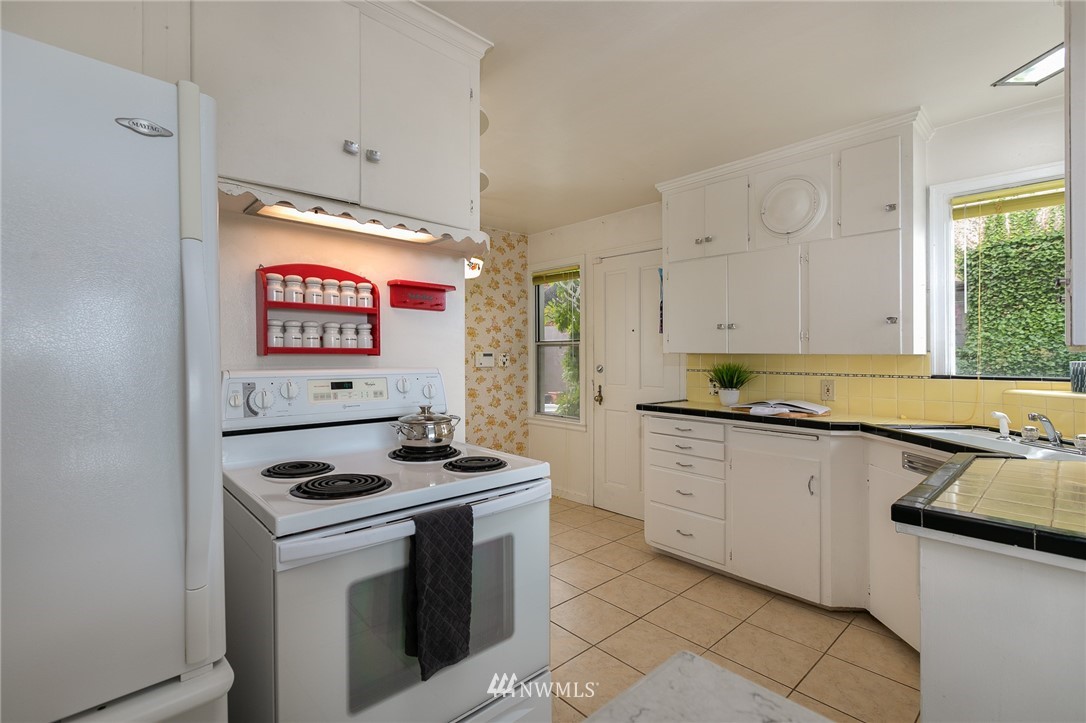 6712 42nd Avenue Southwest Seattle, WA 98136 - Photo 13 of 19 a kitchen with stainless steel appliances a stove a sink and a refrigerator