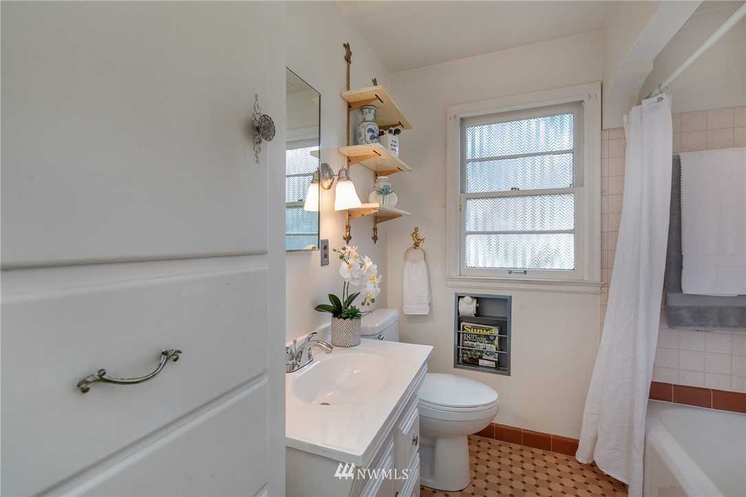 6712 42nd Avenue Southwest Seattle, WA 98136 - Photo 15 of 19 a bathroom with a sink toilet and window