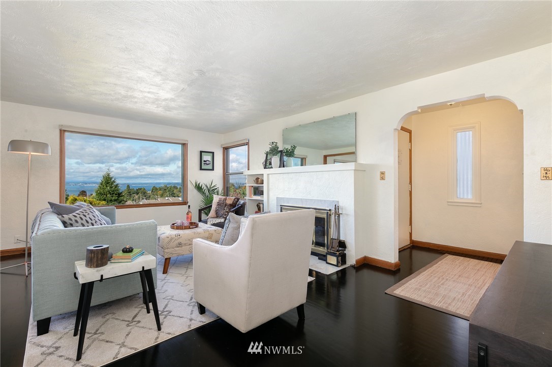 6712 42nd Avenue Southwest Seattle, WA 98136 - Photo 6 of 19 a living room with furniture a large window and a fireplace