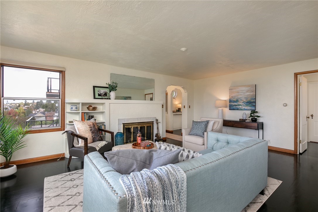 6712 42nd Avenue Southwest Seattle, WA 98136 - Photo 7 of 19 a living room with furniture and a fireplace