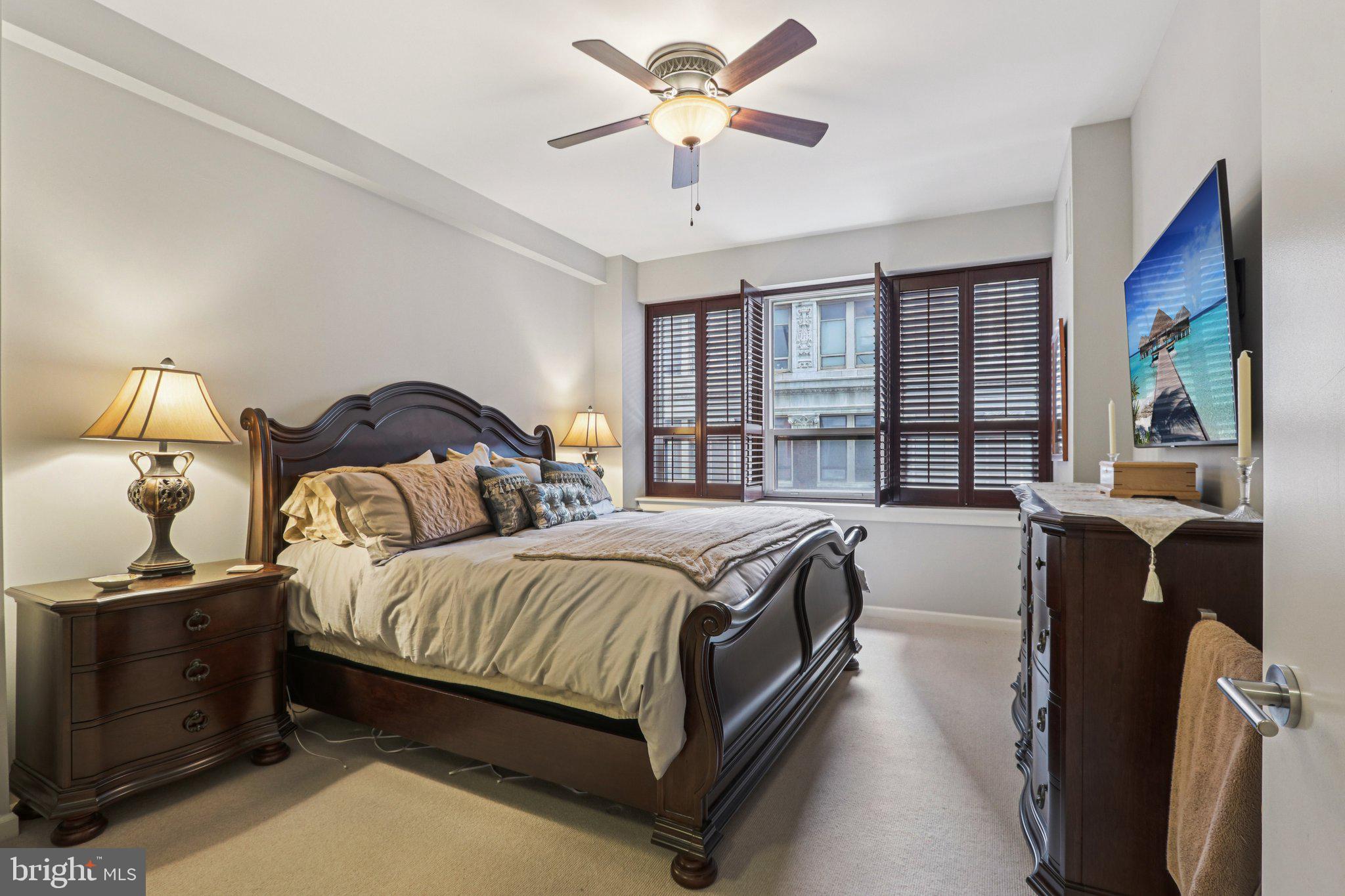 1425 Locust Street, Unit 7D Philadelphia, PA 19102 - Photo 18 of 39 a bedroom with a large bed and a chandelier fan