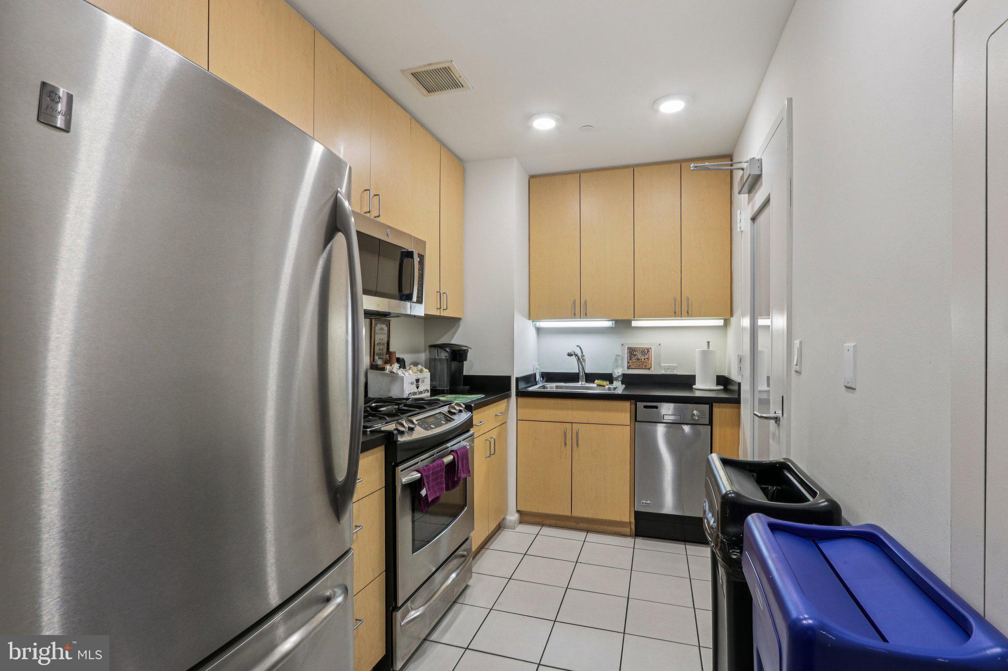 1425 Locust Street, Unit 7D Philadelphia, PA 19102 - Photo 30 of 39 a kitchen with stainless steel appliances granite countertop a refrigerator and a stove top oven