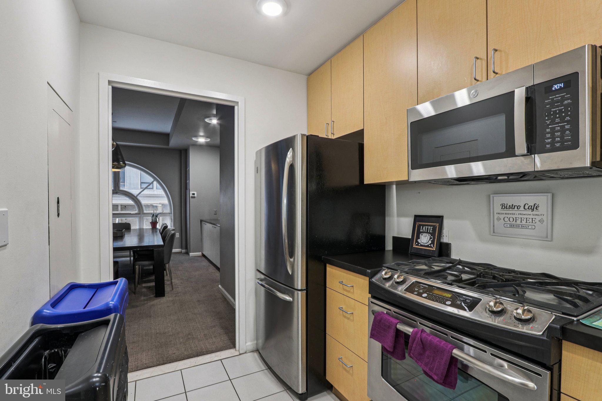 1425 Locust Street, Unit 7D Philadelphia, PA 19102 - Photo 31 of 39 a kitchen with stainless steel appliances granite countertop a stove a refrigerator and a microwave