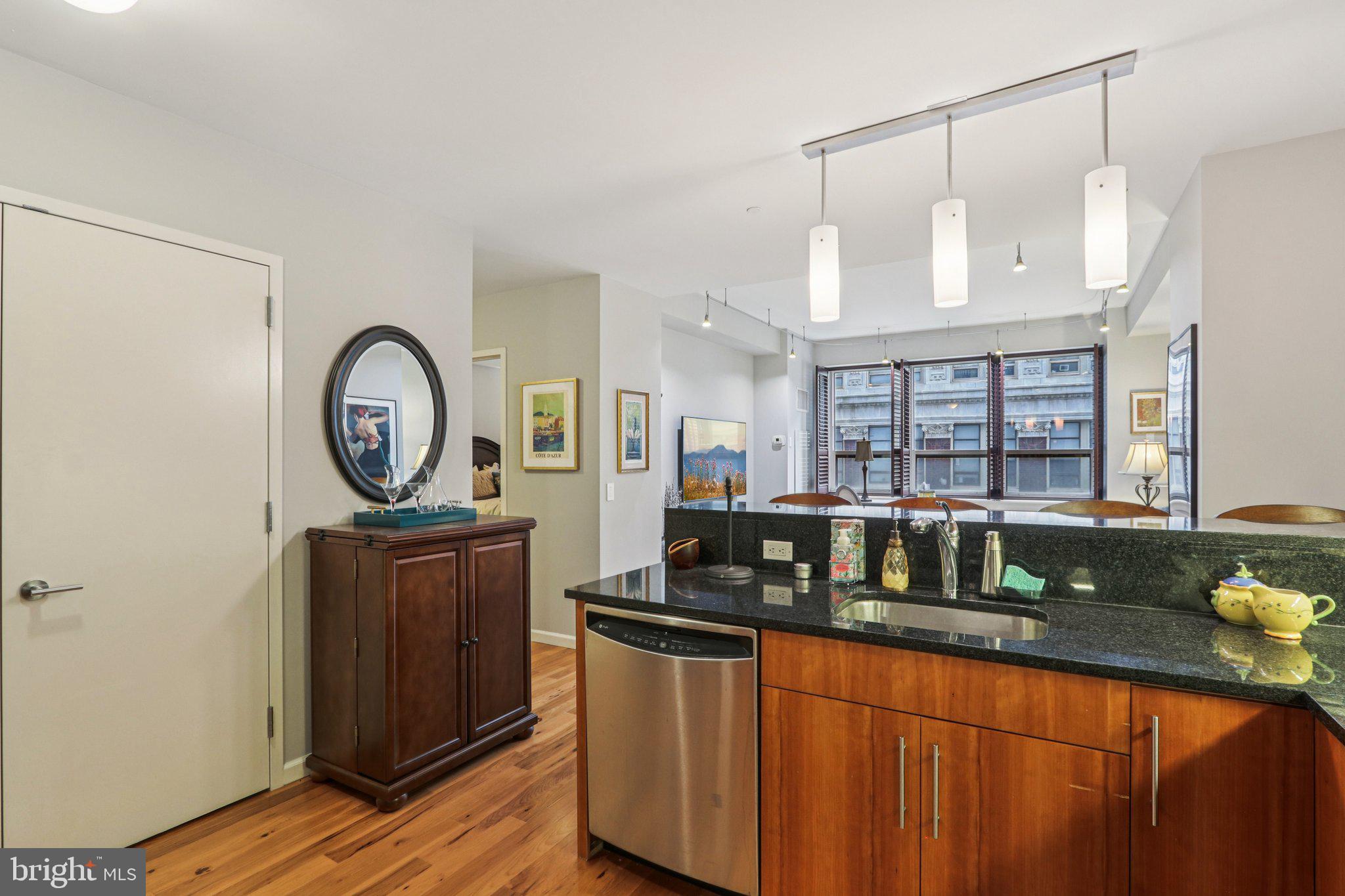 1425 Locust Street, Unit 7D Philadelphia, PA 19102 - Photo 8 of 39 a kitchen with granite countertop a stove a sink and a wooden cabinets
