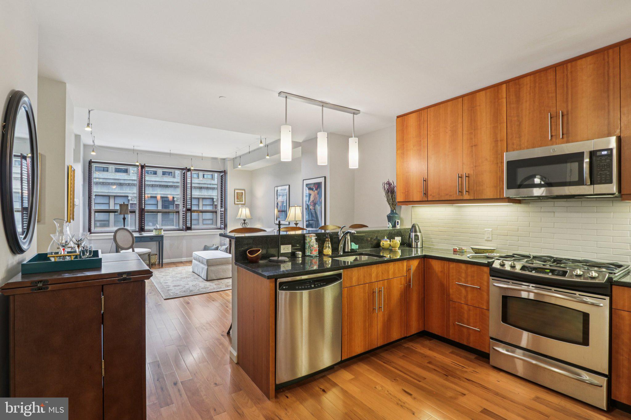 1425 Locust Street, Unit 7D Philadelphia, PA 19102 - Photo 9 of 39 a kitchen with stainless steel appliances a stove a sink and a microwave