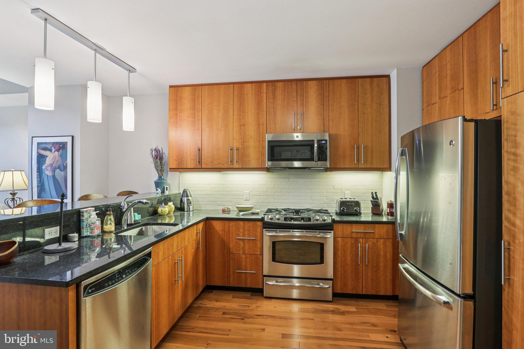 1425 Locust Street, Unit 7D Philadelphia, PA 19102 - Photo 10 of 39 a kitchen with stainless steel appliances granite countertop a stove a refrigerator and a sink
